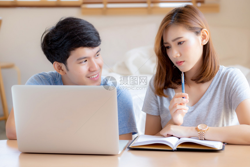 美丽的年轻夫妇计算笔记本电脑和规划费用妇女一起写笔记本或事家庭生活方式家庭和商业概念图片