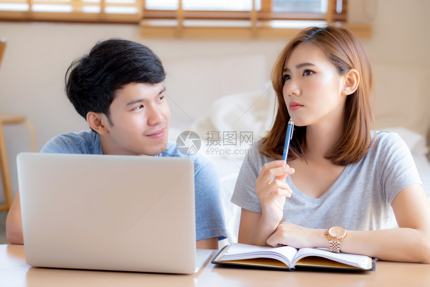 美丽的年轻夫妇计算笔记本电脑和规划费用妇女一起写笔记本或事家庭生活方式家庭和商业概念图片