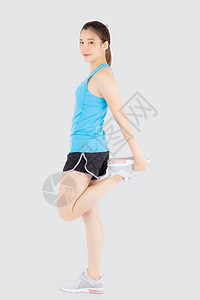 参加运动的美丽年轻女站在运动的肌肉伸展腿运动健康与白种背景隔绝图片