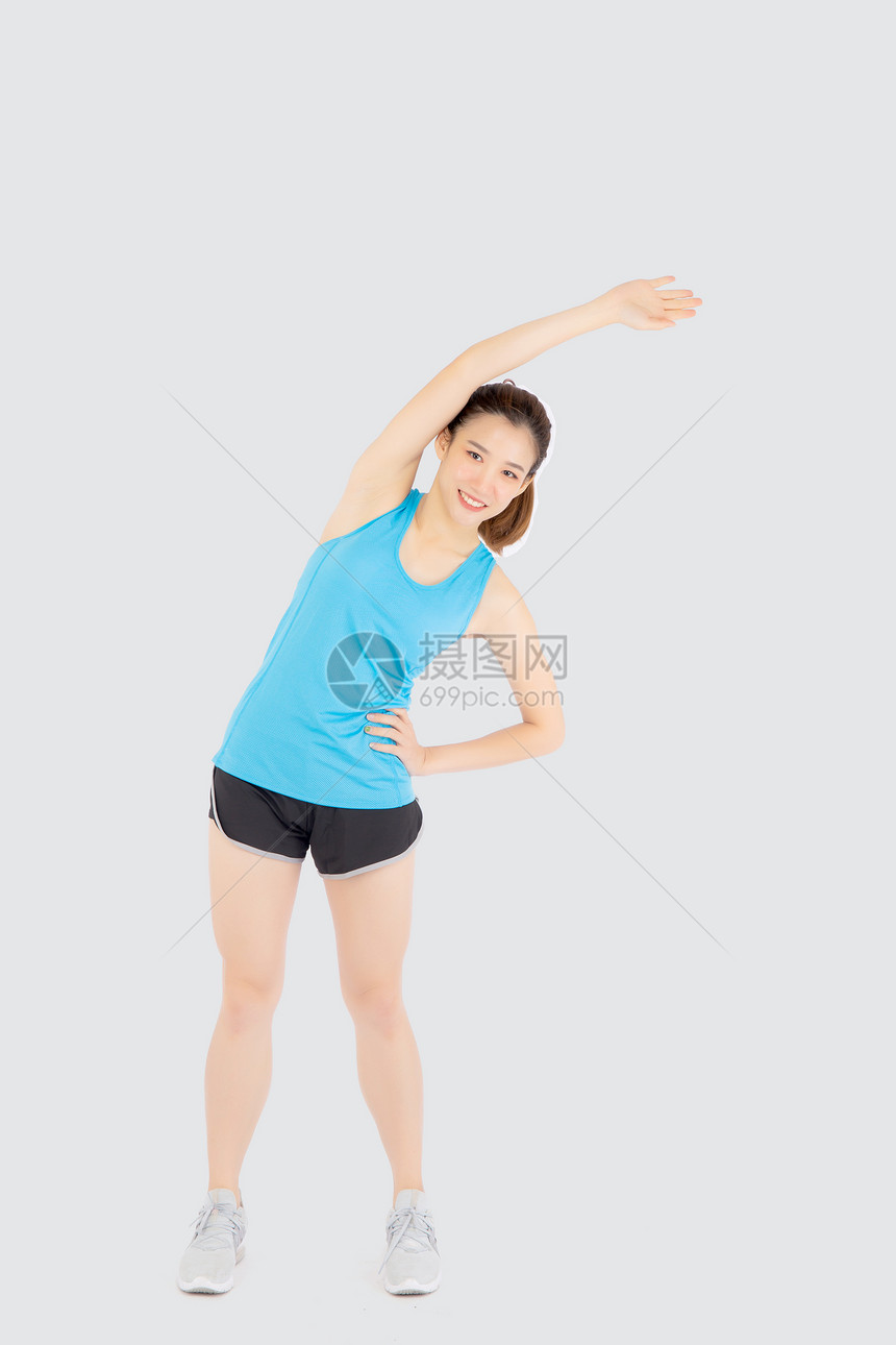 运动中的美丽年轻女站在肌肉伸展的手臂上锻炼身体健康与白人隔绝女孩穿着体型暖和运动锻炼瑜伽健康概念图片