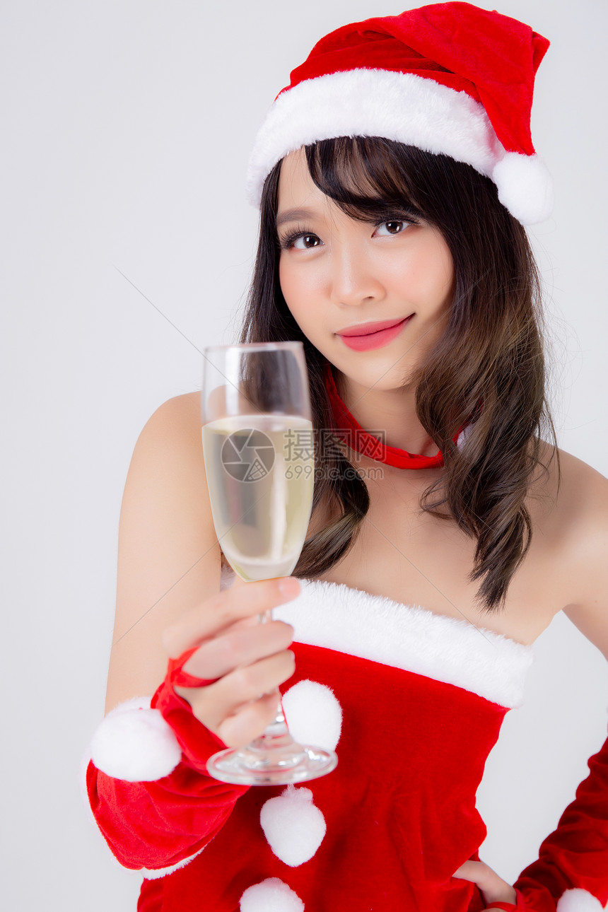 圣诞老人中年轻的女拿着香槟杯在圣诞节庆祝日白种背景女孩喝饮料圣诞节和新年概念图片