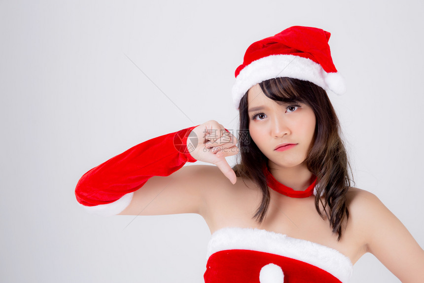 美丽的年轻女肖像圣诞老人装扮手势的拇指向下图片
