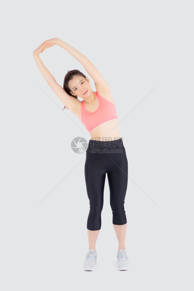 运动中的美丽年轻女站在肌肉伸展的手臂上锻炼身体健康与白人隔绝女孩穿着体型暖和运动锻炼瑜伽健康概念图片