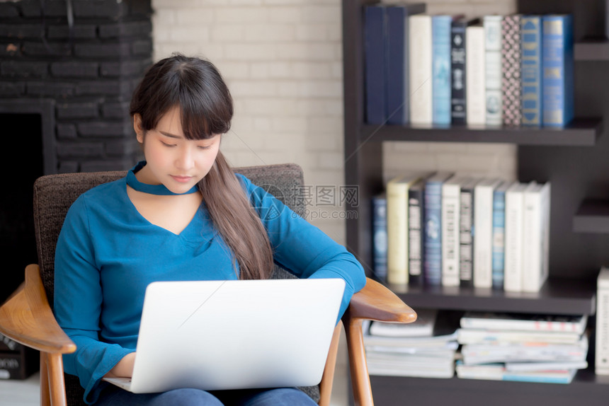商业青年女自由职者从事在椅子上展示膝型计算机的工作女商人检查电子邮件女青年搜索互联网通信和商业概念图片
