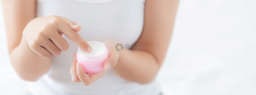 使用润湿剂或滑护肤奶油化妆品产拥有治疗湿润身体护理健康与概念的女孩图片