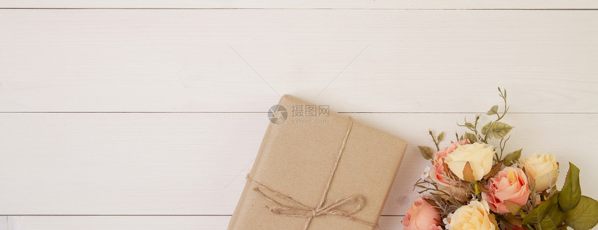 美丽的花朵和礼物盒放在浪漫的木制背景上赠送母亲日或情人节图片