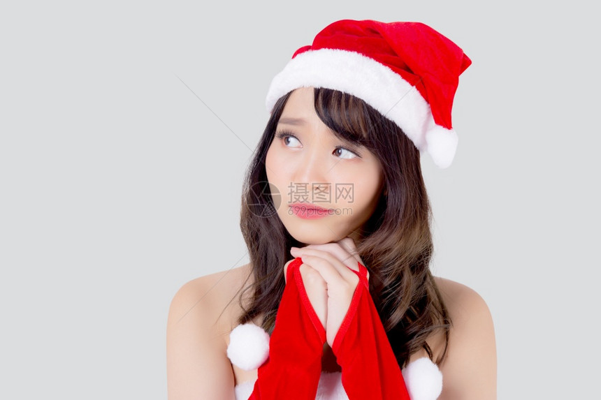 美丽的肖像年轻的亚洲妇女圣诞老人服装戴着帽子微笑和思考在节日圣诞节美丽的模型亚洲女孩快乐和幸福庆祝圣诞节隔离在白色背景上图片