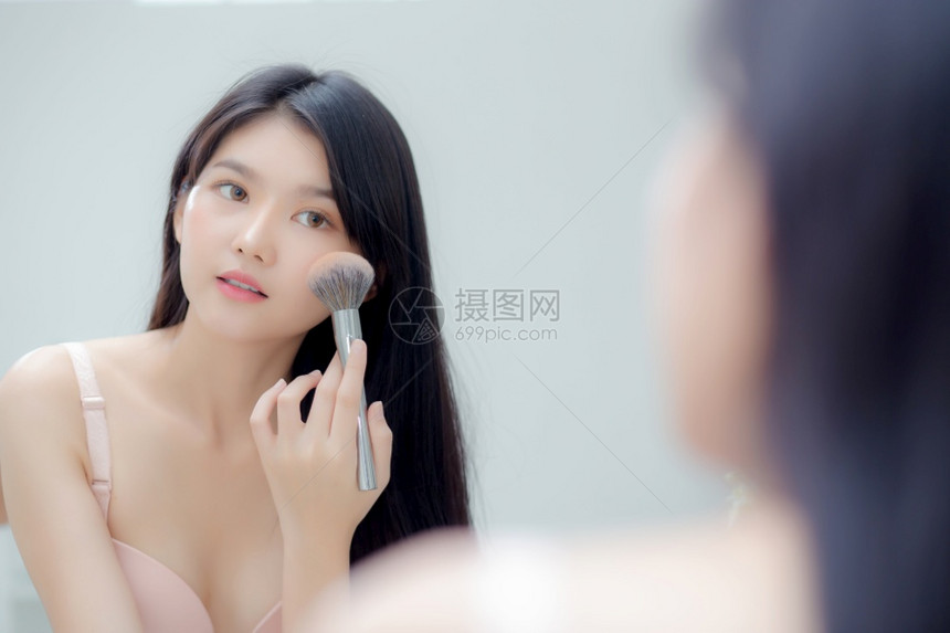 美容肖像年轻的亚洲女微笑着面容的镜子满脸红的镜子在房间里化妆快乐的美丽女孩脸红面部皮肤护理和化妆念图片