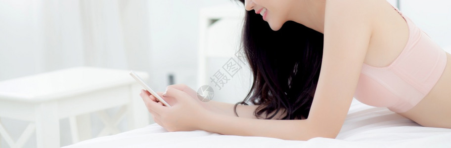 衣着内的女孩在床上智能手机交流与生活方式概念横幅网站等社交媒体上寻找图片