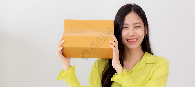 铲头装货年轻女在家中微笑并拿着纸板盒快乐女携带包裹盒兴奋赠送和礼物包装货网上购物商店和服务概念背景