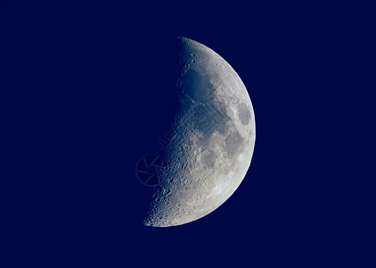 第一季度的月亮以天文望远镜深蓝天空背景看到第一季度的月亮以望远镜看到图片