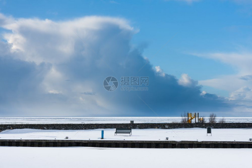 冬天冰冻的荷兰港湾和海滩冬天被雪覆盖而大雷暴正从海上袭来图片