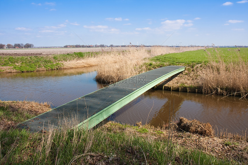 荷兰农田有行人桥穿过宽阔的沟渠图片