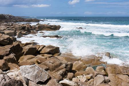 冲破法国布列塔尼岩石海岸的波浪图片
