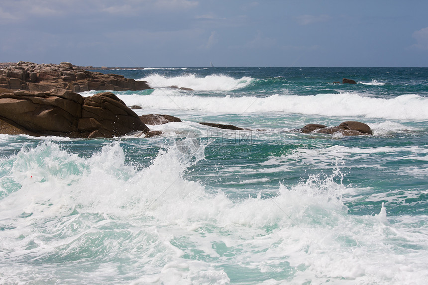 冲破法国布列塔尼岩石海岸的波浪图片