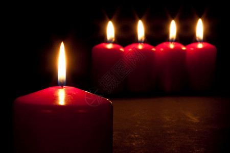 在黑暗中燃烧的红色蜡烛背景图片