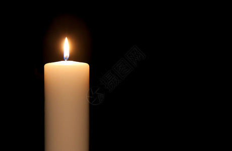 白色燃烧的蜡烛在黑色背景下隔绝的白蜡烛背景
