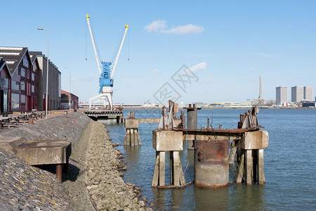 在荷兰鹿特丹港与工厂建筑和起重机交汇的Quayside图片