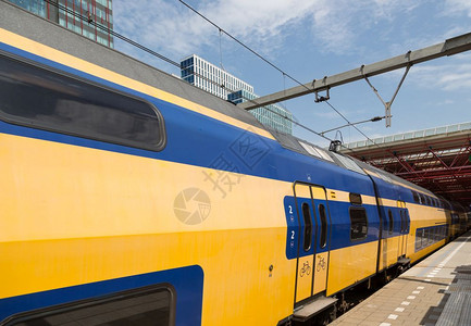 荷兰黄色双层甲板列车正在离开火站背景图片