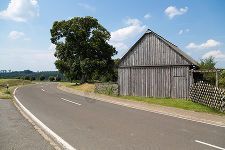 德国一条农村公路沿线的旧木头谷仓背景图片