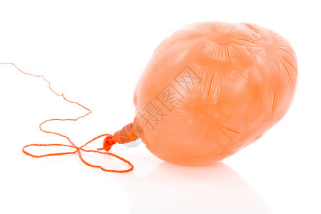 泄气绳索上淡化的橙色气球在白背景上隔开背景