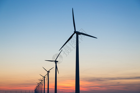 日落时风力涡轮机的光图片