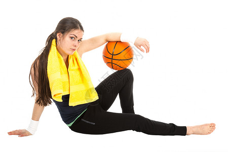 运动中的漂亮女子穿着篮球坐在地板上与白种背景隔绝图片
