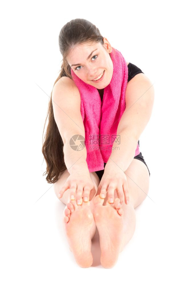身穿紫毛巾的坐着妇女前视线手伸向脚在白色上孤立图片