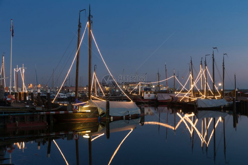 在荷兰乌尔克港夜照光的传统木制渔船图片