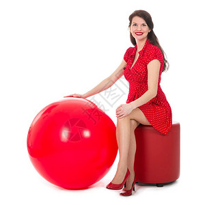 穿着红裙子的美女坐在脚凳上拿着一个大红气球图片