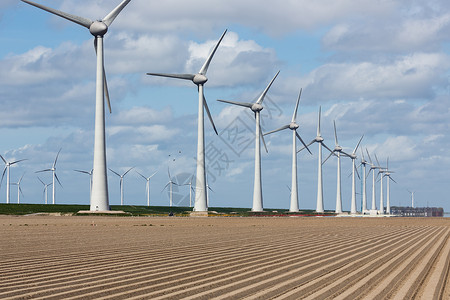 荷兰风力涡轮机和春初犁田条纹的荷兰风景图片