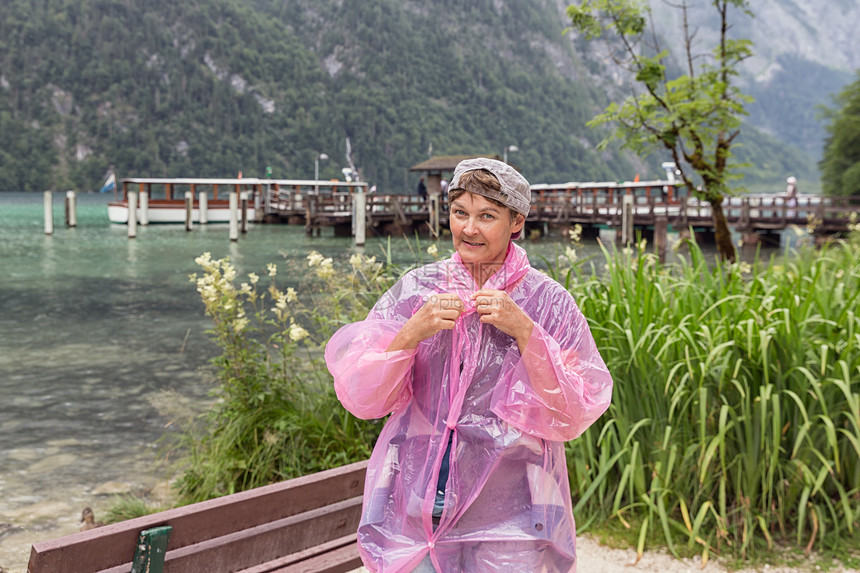 德国阿尔卑斯山脉Berchtestesgaden附近Konigssee海岸有雨衣的妇女图片