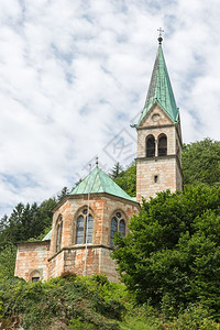 在德国贝希特斯加登与山坡对面的塔台山坡与树木立的教堂休胡特在德国贝希特斯加登与山坡对面的塔台立木头教堂背景图片