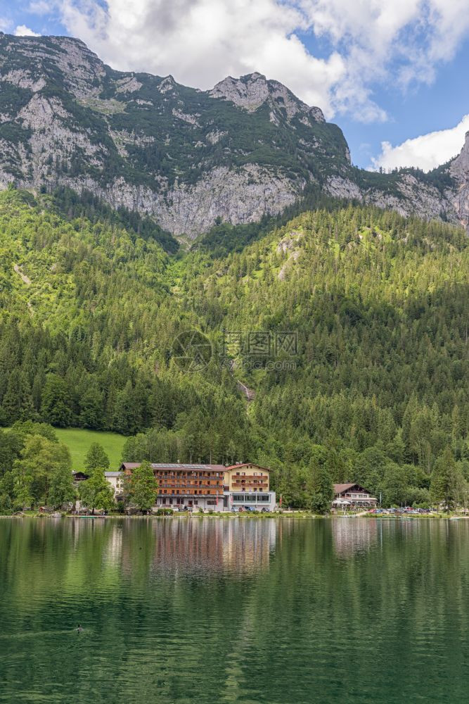 在巴伐利亚阿尔普斯的拉姆苏附近Hintersee湖岸沿线有盛开花和旅馆在巴伐利亚阿尔普斯的拉姆苏附近Hintersee湖和酒店图片