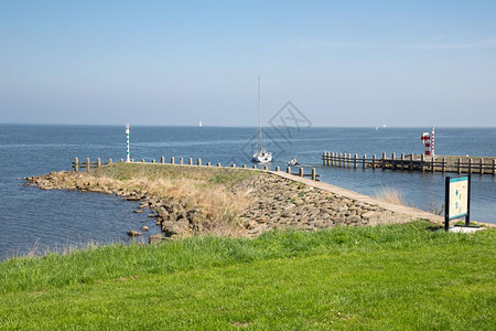 小码头荷兰Medemblik港附近停泊在荷兰Medemblik港防水附近航行的船舶背景