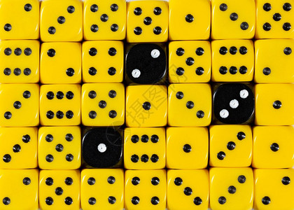 含有三个黑色立方体的随机订购黄色骰子的图样背景含有三个黑色立方体的随机订购黄色骰子的背景背景图片