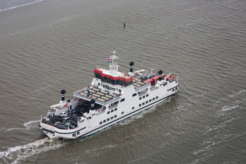 荷兰在瓦登海的渡船载有乘客和汽车从Holwerd驶往阿梅兰岛在Wadden海的荷兰渡船驶往Beween沙滩图片