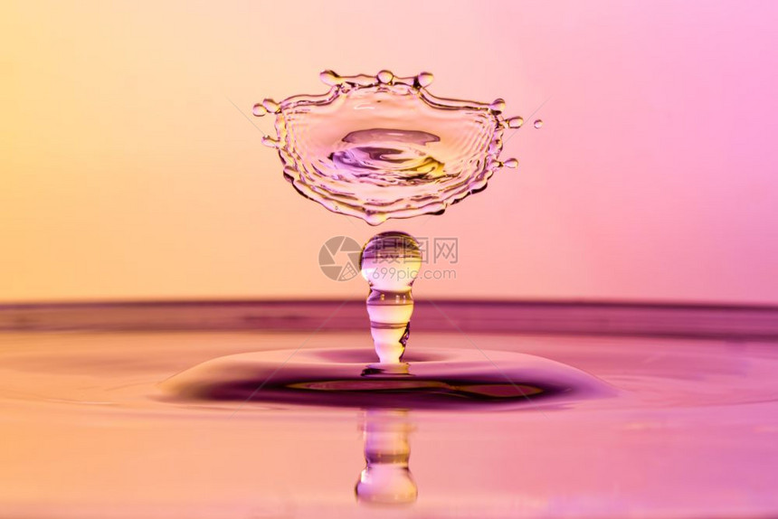 高速度水滴照片与相撞的橙色和紫相交滴图片