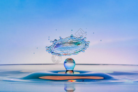 高速度水滴照片与相撞的蓝色粉和紫相交滴图片