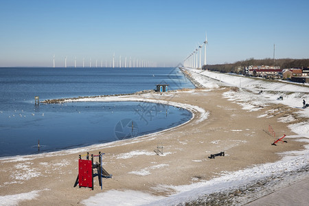 冬季荷兰海滩沿岸有一排风力涡轮机图片