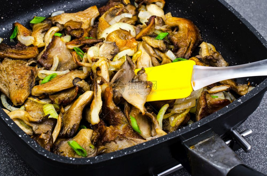 煎锅中炒洋葱的牡菇蘑工作室照片煎锅中炒洋葱的牡菇蘑图片
