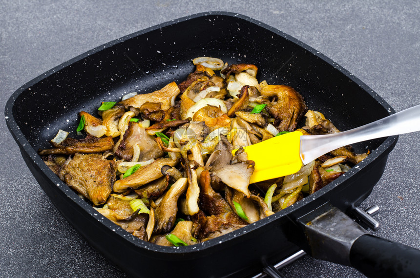 煎锅中炒洋葱的牡菇蘑工作室照片煎锅中炒洋葱的牡菇蘑图片