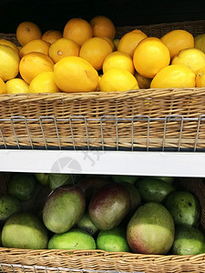 在超市的维基篮子里放柠檬和绿芒果在超市的维基篮子里放柠檬和绿芒果图片