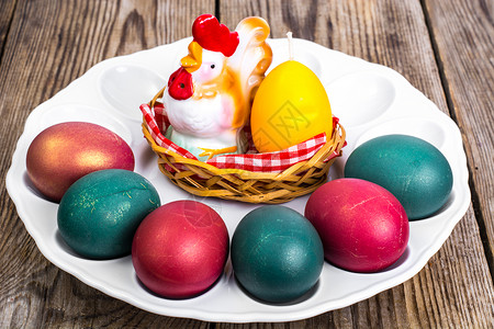在调色半边盘上的彩色鸡蛋和母鸡装饰物图片