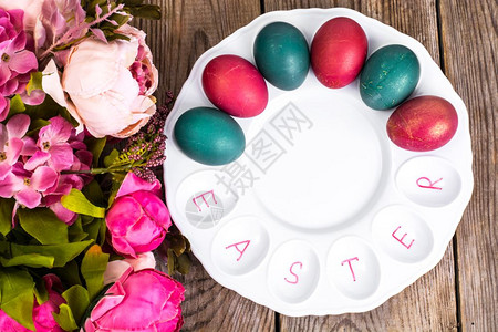 调色盘上的彩色鸡蛋和鲜花图片
