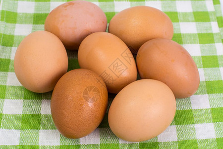 近视图绿白格子桌布上的鸡蛋背景图片