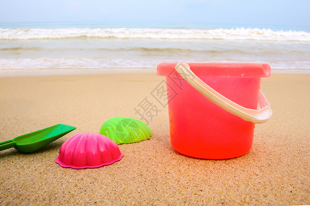 儿童在沙滩上的桶子和彩色模图片
