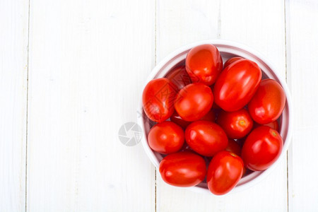 摄影棚照片木制桌上的红熟小西柿顶层视图木制桌上的小红成熟西番茄顶层视图图片
