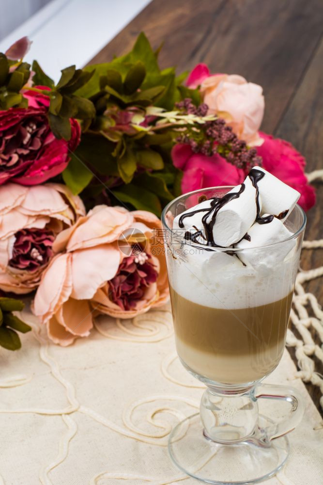 玫瑰花背景的拿铁咖啡图片