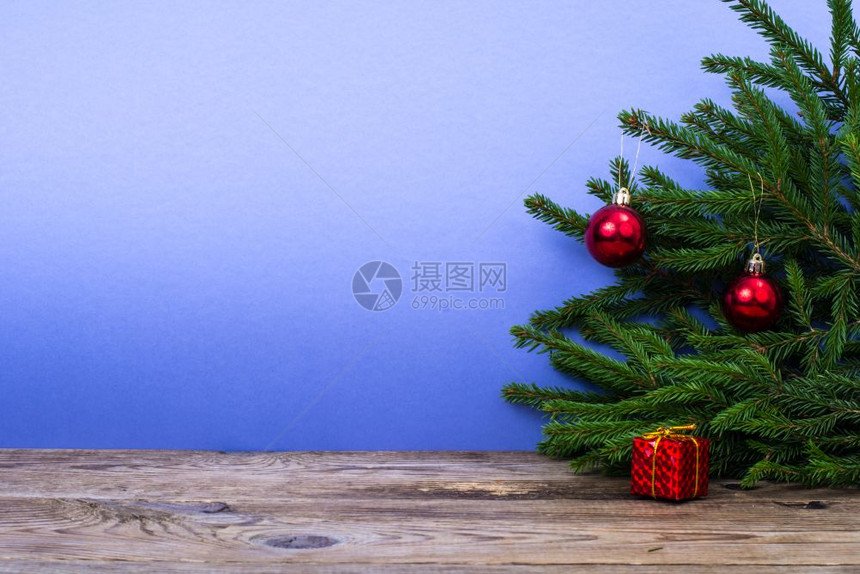木制桌和树枝配有明彩背景的圣诞装饰品工作室照片木制桌和树枝配有明彩背景的圣诞装饰品图片